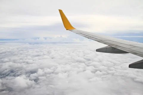 Wing of the plane on sky background - view from the window of a plane Stock Photos