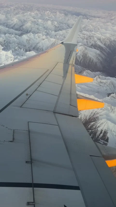 Wing of the plane with snow-covered mountains in the background. Stock Footage 306147146