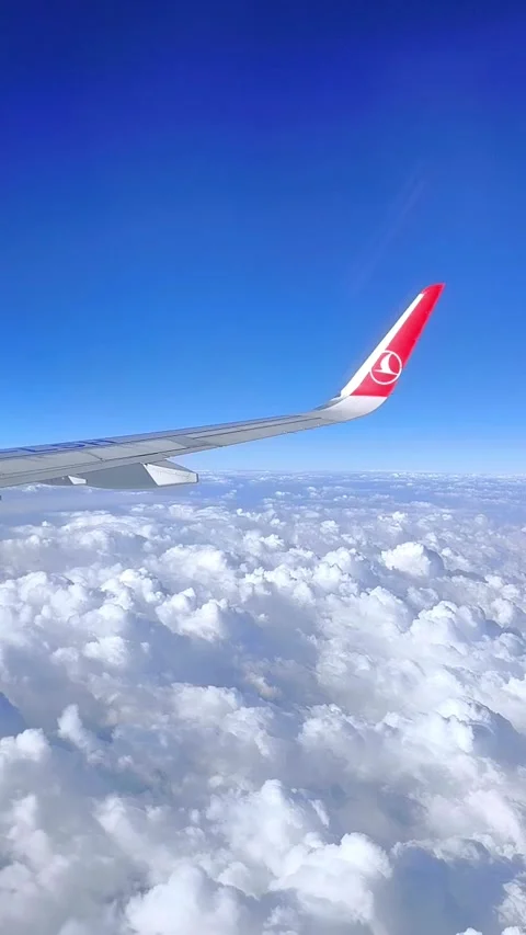 The wing of a plane with the Turkish Airlines logo flying above thick white Stock Footage 320373928