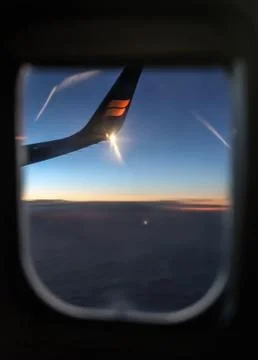 The wing of the plane from the window of the plane. Sun glare. Window airplane Stock Photos