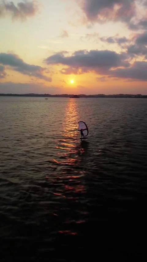 Wing Surfer Gliding on Ocean at Sunset with Clouds and Golden Reflections Stock Footage 321153552
