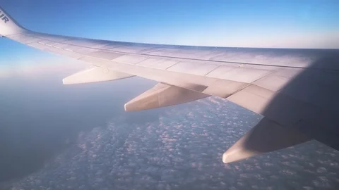 Wing view from airplane window while flying over white clouds Stock-Footage 121618288