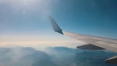 Wing view of a plane flying over the mountains Stock Footage 82393777