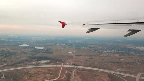 Wing from the window of a passenger plane taking off over the city of Moscow Stock Footage 116734319