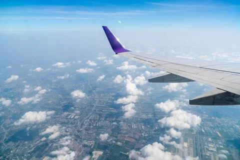 The wings of the plane on the background of blue sky and clouds beautiful. Stock Photos