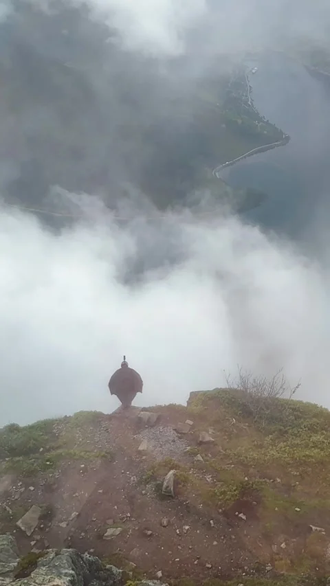 Wingsuit base jumper preparing and jumping from mountain cliff in Norway Stock Footage 315158251
