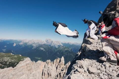 Wingsuit BASE jumping team jumping from cliff, Italian Alps, Alleghe, Belluno, Stock Photos