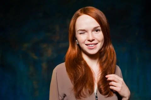 Winking red-haired woman posing Stock Photos