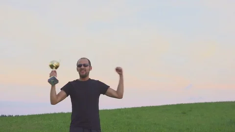 The winner with a cap in his hands raises his hands, enjoys success. 스톡 동영상 108010284