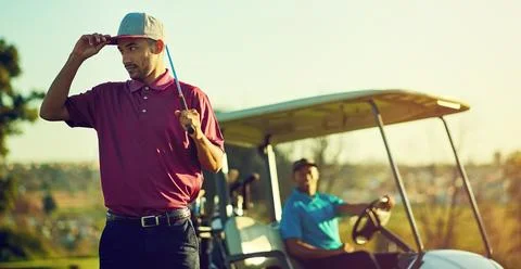 Winners train, losers complain. a golfer holding his club with a buggy blurred Stock Photos