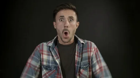  Winning man exulting looking at camera on neutral background  Stock Footage 80303578