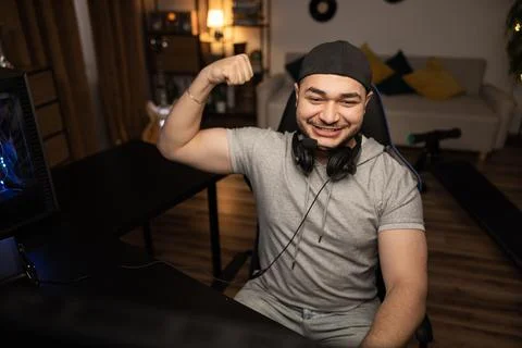 Winning round in a computer video game. A bearded man with a headset enjoys the Stock-Fotos