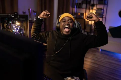 Winning round in computer video game. A man in cap and sweatshirt with headset Stock-Fotos