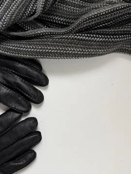 Winter accessories on a clean white surface. A dark grey knitted scarf. Foto stock