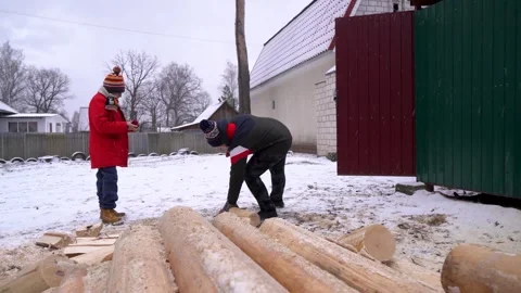 Winter activities in the countryside featuring log chopping and children playing Vídeo Stock 310681087