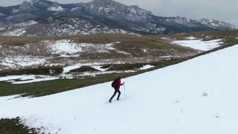 Winter activities. A man with a backpack and Nordic walking poles climbs the slo Stock-Footage 150564792