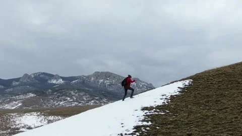Winter activities. A man with a backpack and Nordic walking poles climbs the slo Stock Footage 150565127