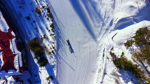 Winter activities take place in the snowy landscape as people enjoy sledding on 스톡 동영상 336605301