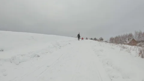 Winter activity, mom rolls son on sleigh Stock Footage 122495548