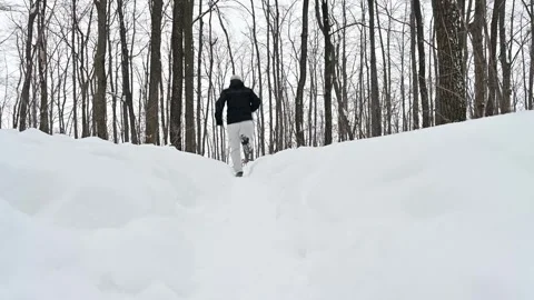 Winter adventure as a man races down a snowy mountain trail Stock Footage 338414353