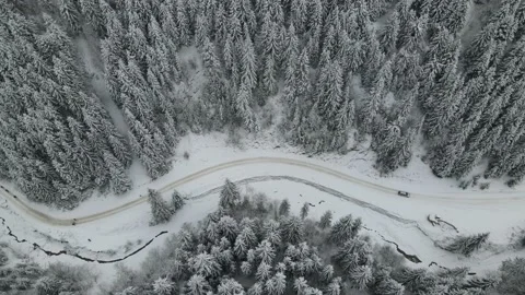 Winter aerial top view from drone - car vehicle driving on snowy forest road Stock Footage 220356312