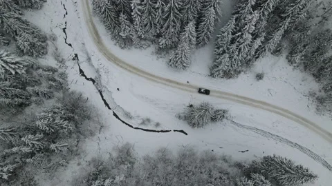 Winter aerial top view from drone - car vehicle driving on snowy forest road Stock Footage 220356543