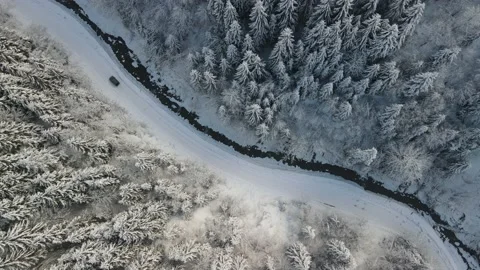 Winter aerial top view from drone - car driving on snowy forest road tracking Stock Footage 220438249
