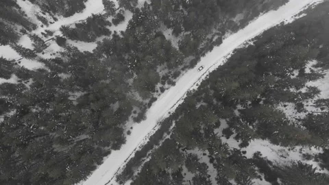 Winter aerial top view from drone - car vehicle driving on snowy forest road Stock Footage 221789446