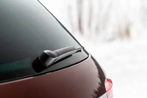 Winter back car window. A car wiper cleans the rear window. Stock Photos