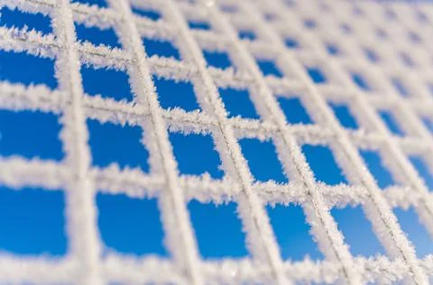 Winter background chain-link mesh fence covered with a continuous layer of wh Stock Photos