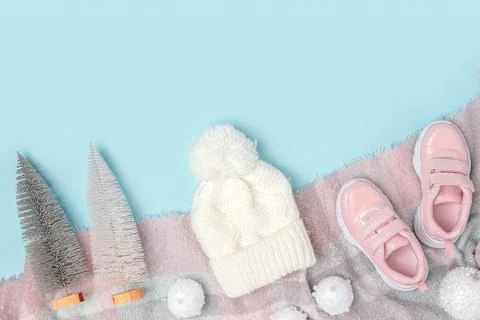 Winter background with copy space. White knitted hat, pink sneakers and scarf Stock Photos
