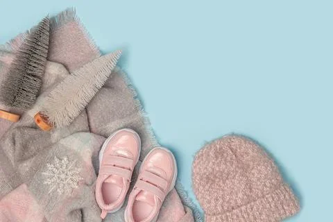 Winter background with copy space. White knitted hat, pink sneakers and scarf Stock Photos