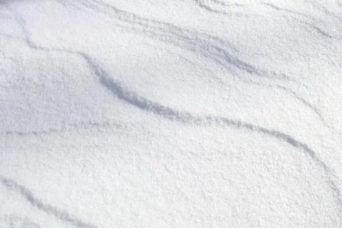 Winter background with snowy ground. Wind sculpted patterns on snow surface. Stock Photos