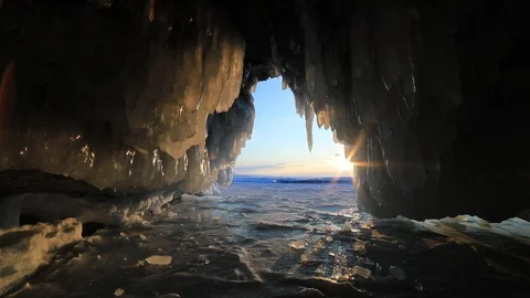 Winter Baikal. Ice cave with icicles at sunset. Stock Footage