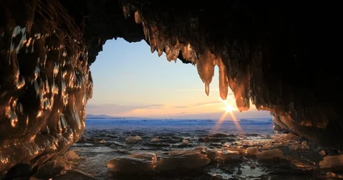 Winter Baikal. Ice cave with icicles at sunset. Stock Footage 89481793