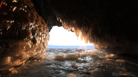 Winter Baikal. Ice cave with icicles at sunset. Stock Footage 89482174