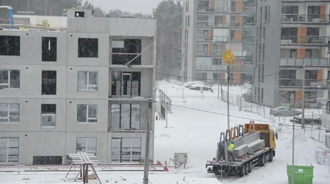 Winter blizzard and workers with crane lift block house part Stock Footage 49899436