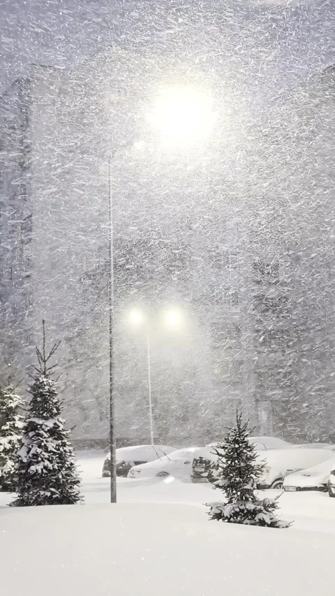 Winter blizzard, heavy snowfall under bright streetlights at night. Snowstorm, Stock Footage 326750549
