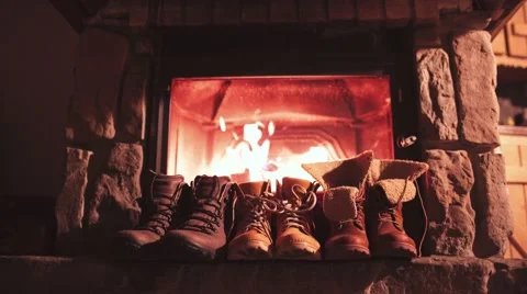 Winter Boots drying in front of a Cozy Burning Fireplace 4K. Stock Footage