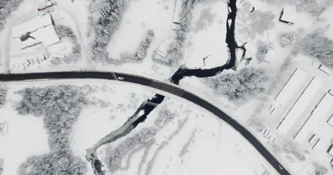 Winter Bridge Over a Dark River Cutting Through Snow Stock Footage 334939008