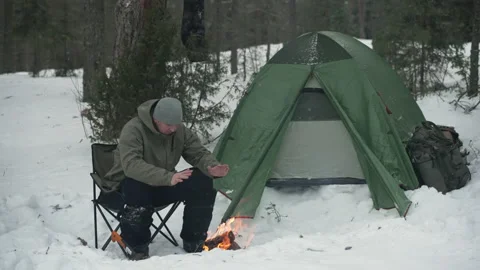 Winter camp with a fire in the forest. Camping, hiking concept. Stockbeeldmateriaal 169302677