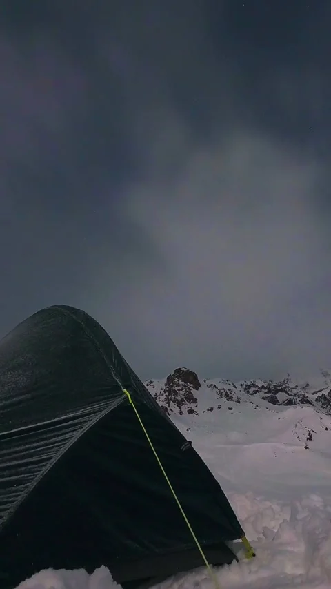 Winter camping tent in snowy alpine mountains during stormy night. Timelaps.. Stock Footage 341872010
