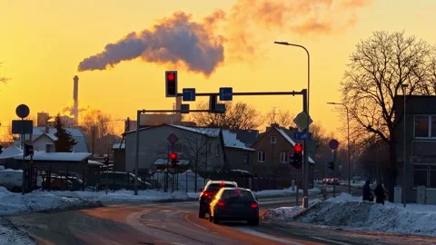 Winter city intersection at sunset with red traffic lights, passing cars Stock Footage 333318532
