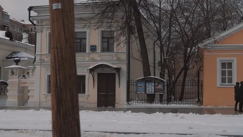 Winter city street with old architecture style buildings covered in snow Stock Footage