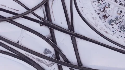 Winter city traffic moving through snowy highway interchange aerial Stock Footage 328963185