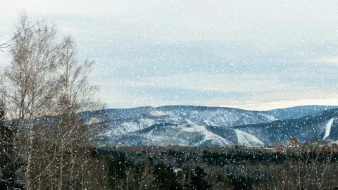 Winter cityscape on the background of mountains, falling snow Stock Footage 120498179