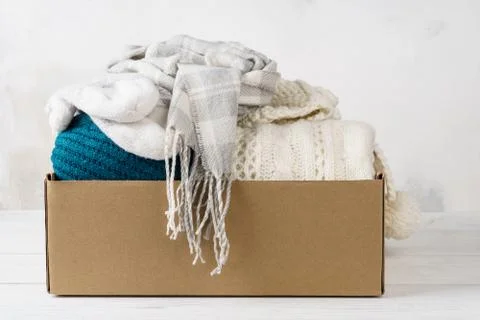 Winter clothes in a cardboard box. Seasonal clothing. Stock Photos