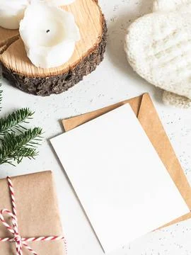 Winter composition of knitted mittens, envelope and paper card, candles and.. Stock Photos