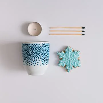 Winter composition made with tea cup, snowflake cookie, matches and candle. M Foto stock