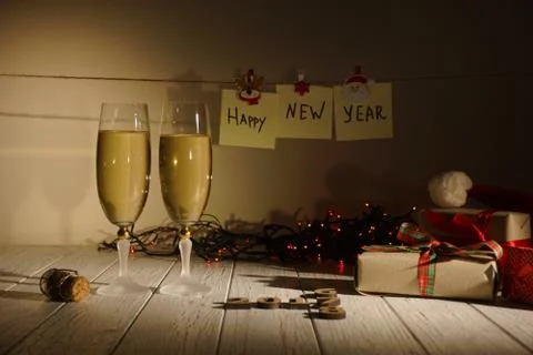 Winter composition. Wrapped presents, two glasses of champagne and glowing Stock Photos